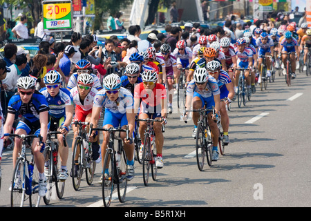 I ciclisti nel peloton ride passato la folla, Tour de Taiwan fase 1 crtierium, Kaohsiung, Taiwan, ROC Foto Stock