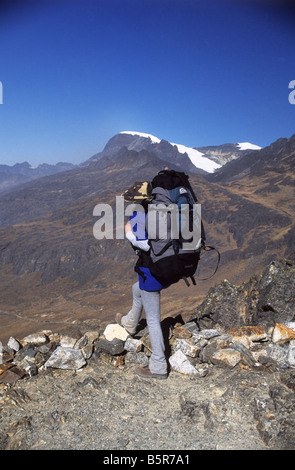 Trekker guardando a vista sul Takesi Inca Trail da Abra Takesi, Mount Mururata in background, Cordillera Real, Bolivia Foto Stock