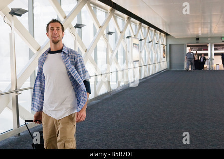 Giovane uomo a camminare per il gate all'Aeroporto Internazionale di San Francisco, California, Stati Uniti d'America Foto Stock