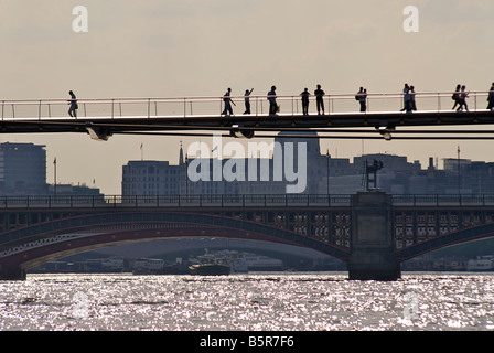 Pedoni sul Millennium ponte che attraversa il fiume Tamigi. Londra, Inghilterra Foto Stock