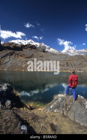 Trekker guardando il panorama del Lago Chillata, MTS e Illampu Ancohuma in background, Cordillera Real, Bolivia Foto Stock