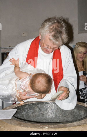 Curato vicario reverendo battezzare battezzare Bambina bambino Foto Stock