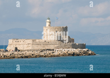 St Nicholas faro nel porto di Mandraki, Rodi, Grecia, battenti bandiera greca e con la costa della Turchia in background Foto Stock