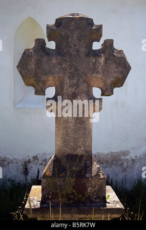 Rusty croce di pietra sul sagrato della chiesa Foto Stock