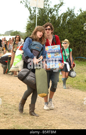 Glastonbury Festival giugno 2008 i frequentatori del festival fans primo giorno arrivi con zaini pesanti tende e sacchi a pelo arrivano di birra Foto Stock