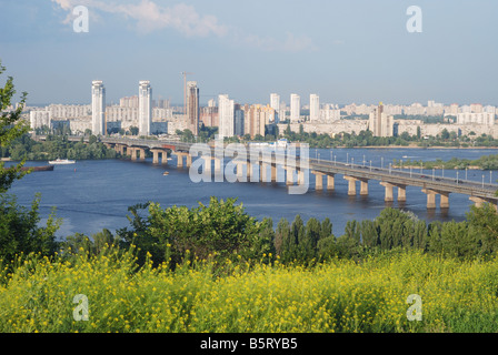 Ponte di Paton sul fiume Dnipro, remoto distretto residenziale di fiume eft-bank, Riverside rank estate erba in primo piano Foto Stock