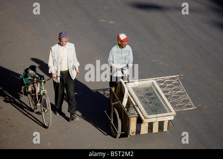 Gli uomini di trasportare la costruzione di materiali di consumo in un carrello, Er Rachidia, Marocco, Africa del Nord Foto Stock