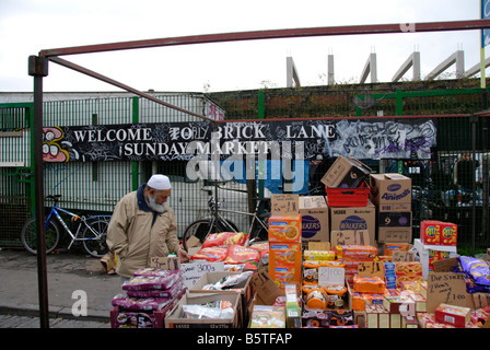 Musulmani asiatici ispezionando l uomo del cibo su Brick Lane market stall London Inghilterra England Foto Stock