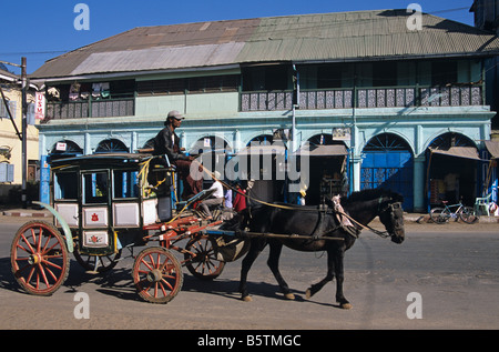 Cavallo e Carrozza trot passato edifici coloniali sulla strada principale di Pyin U Lwin, ex Maymyo, in Birmania o Myanmar Foto Stock