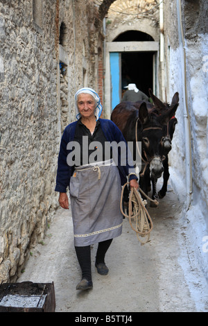 Vecchia donna greca con gli asini nel villaggio di Pyrgi sull isola di Chios Grecia Foto Stock