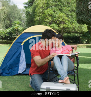 Giovane Azienda una rivista in un parco Foto Stock