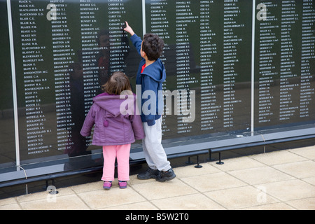 Ragazzo e ragazza di leggere i nomi sulla Battaglia di Bretagna memorial a Capel Le Ferne nel Kent Foto Stock