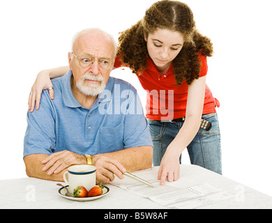 Confuso senior uomo cercando di compilare un absentee ballottaggio con il suo nipote s aiutare isolato su bianco Foto Stock