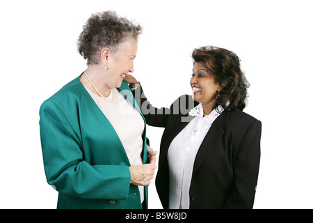 Due etnicamente e età femmina diversi colleghi ridere insieme isolato su bianco con focus sulla piccola donna Foto Stock