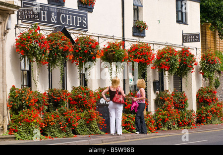 Pesce e Patatine shop con cesti floreali pendenti al di fuori in città rurale di Usk Monmouthshire South Wales UK Foto Stock