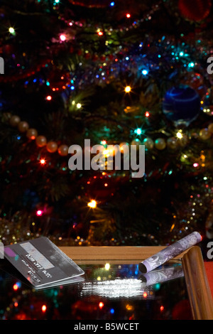 Linee di cocaina simulato su specchio con arrotolato venti sterline contanti nota con platino carta di credito albero di natale Foto Stock