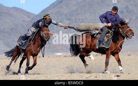 Il kazako due piloti in lotta per il controllo di una capra morto in un gioco di Kokpar o Bushkashi a l'Aquila annuale Festival di caccia Foto Stock