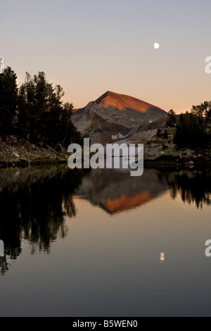 Picco di sentinella e una luna quasi piena si riflette nelle acque del lago glaciale Eagle Cap Wallowa deserto montagna Oregon Foto Stock