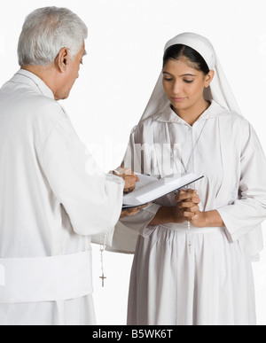 Sacerdote e una suora guardando la Bibbia Foto Stock