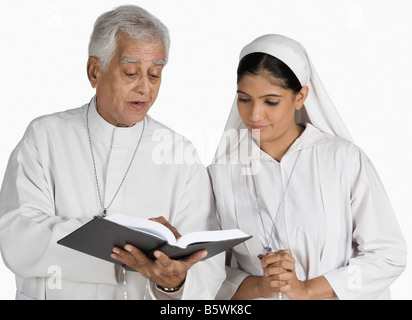 Sacerdote e una suora guardando la Bibbia Foto Stock