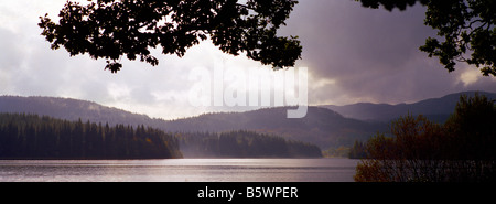 Panorama suggestivo colore colore immagine del sole proveniente attraverso le nuvole sopra Loch Ard, Scozia Foto Stock