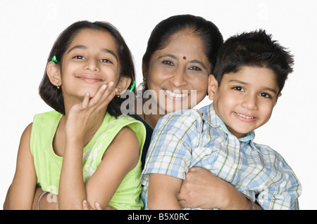 Donna matura che trasportano i suoi nipoti e sorridente Foto Stock