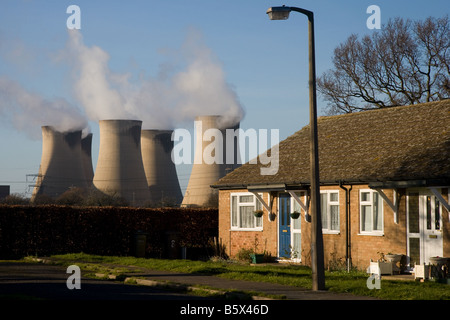 Drax Power Station - bungalows in una tenuta urbana ombreggiata da alte torri di raffreddamento - Selby, West Yorkshire, Inghilterra, Regno Unito. Foto Stock