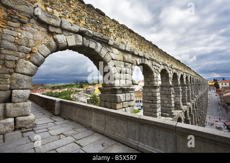 Il ben noto antico acquedotto e antiche Segovia in nuvoloso giorno di maggio Foto Stock