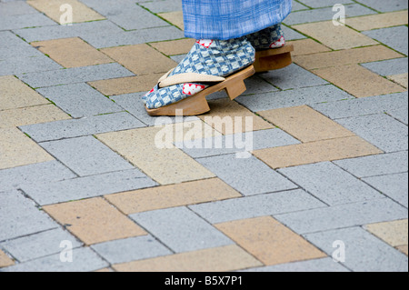 Uomo che indossa geta giapponese di scarpe di legno sotto un kimono in Asakusa, Tokyo, Giappone. Foto Stock