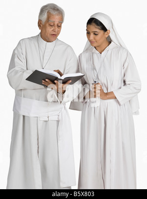 Sacerdote e una suora guardando la Bibbia Foto Stock