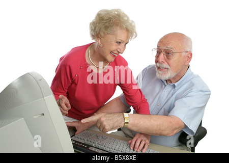 Un senior lady insegnamento un uomo anziano come usare il computer ha un problema isolato su bianco Foto Stock