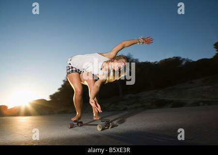 Giovane donna su skateboard Foto Stock