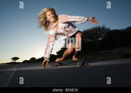 Giovane donna su skateboard Foto Stock