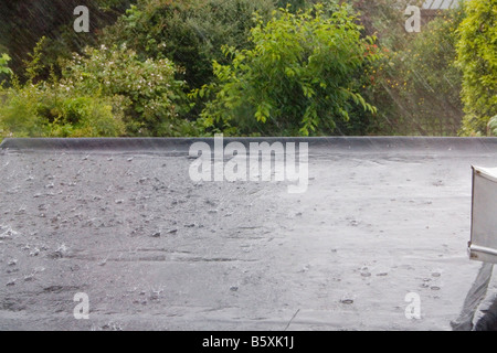 Heavy Rain in summertine sul tetto piatto di una casa in Irlanda Foto Stock