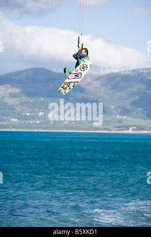 Donna facendo big jump su kiteboard Tarifa Spagna Foto Stock