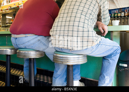 Due patroni seduti a cena in attesa del contatore per il loro cibo e pronto da mangiare. Foto Stock