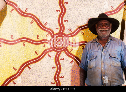 Long Jack Phillipus Tjakamarra, anziano indigeno che sorride di fronte al suo tradizionale dipinto a punti con un cappello a teglia larga Foto Stock