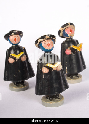 Antica decorazione di Natale ornamento musica tradizionale coro in legno intagliato figurine sfondo bianco intaglio vintage tre cantare Foto Stock