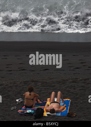 La gente sulla lava nera spiaggia di sabbia dal piccolo villaggio Mosteiros, São Miguel, Azzorre, Portogallo Foto Stock