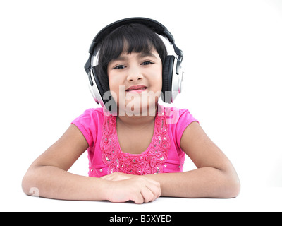 Un grazioso cerca ragazza asiatica di origine indiana ascoltando musica Foto Stock