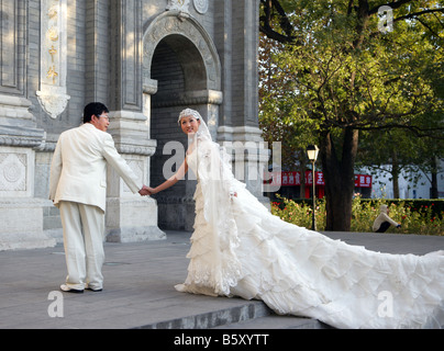 Il cinese sposa e lo sposo in posa per le fotografie del vostro matrimonio chiesa di San Giuseppe Cattedrale di Dongtang Pechino Foto Stock