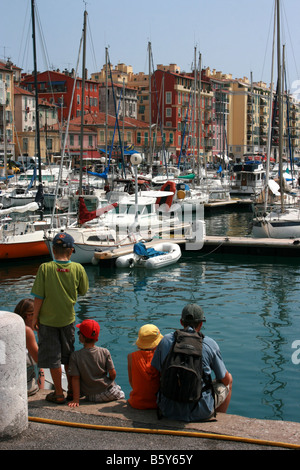 Giovane famiglia in vacanza facendo una pausa al porto di Nizza, Côte d'Azur, nel sud della Francia Foto Stock