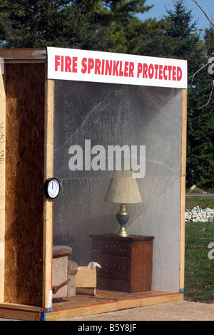 Un display per un sistema antincendio a sprinkler con dimostrazione di soppressione di acqua sul fuoco in un incendio Saftety Fair Foto Stock