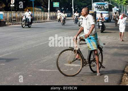 Un maschio ciclista su una bicicletta di utilità in attesa di attraversare la strada di Chennai, nello Stato del Tamil Nadu, India. Foto Stock