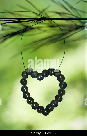 A forma di cuore pulsante perla ornamento pendente dal filo Foto Stock