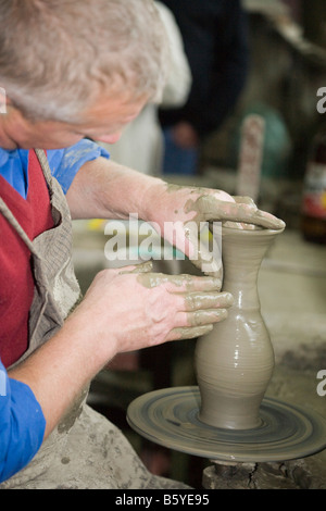 Uomo di gettare una pentola di creta utilizzando tornio del vasaio Foto Stock