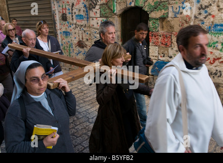 Israele Gerusalemme la città vecchia Via Dolorosa gruppo di pellegrini che porta una croce di legno lungo la via dolorosa Foto Stock