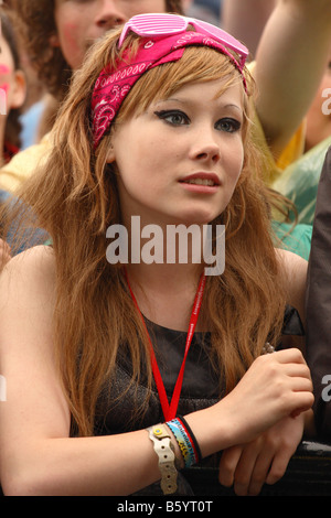 Glastonbury Festival 2008 musica pop ragazza ventola femmina in mezzo alla folla guardando e ballare ascoltando la sensazione band sul palco Foto Stock