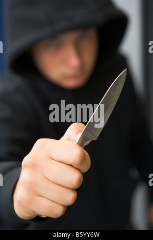 Ragazzo adolescente brandendo il coltello Foto Stock