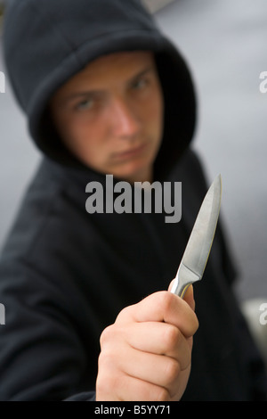 Ragazzo adolescente brandendo il coltello Foto Stock